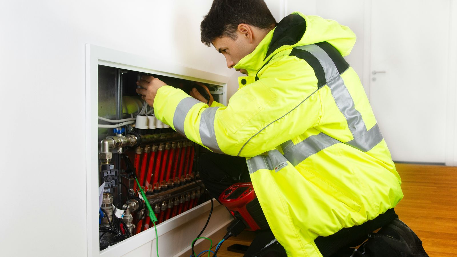 Heating engineer servicing an underfloor heating manifold